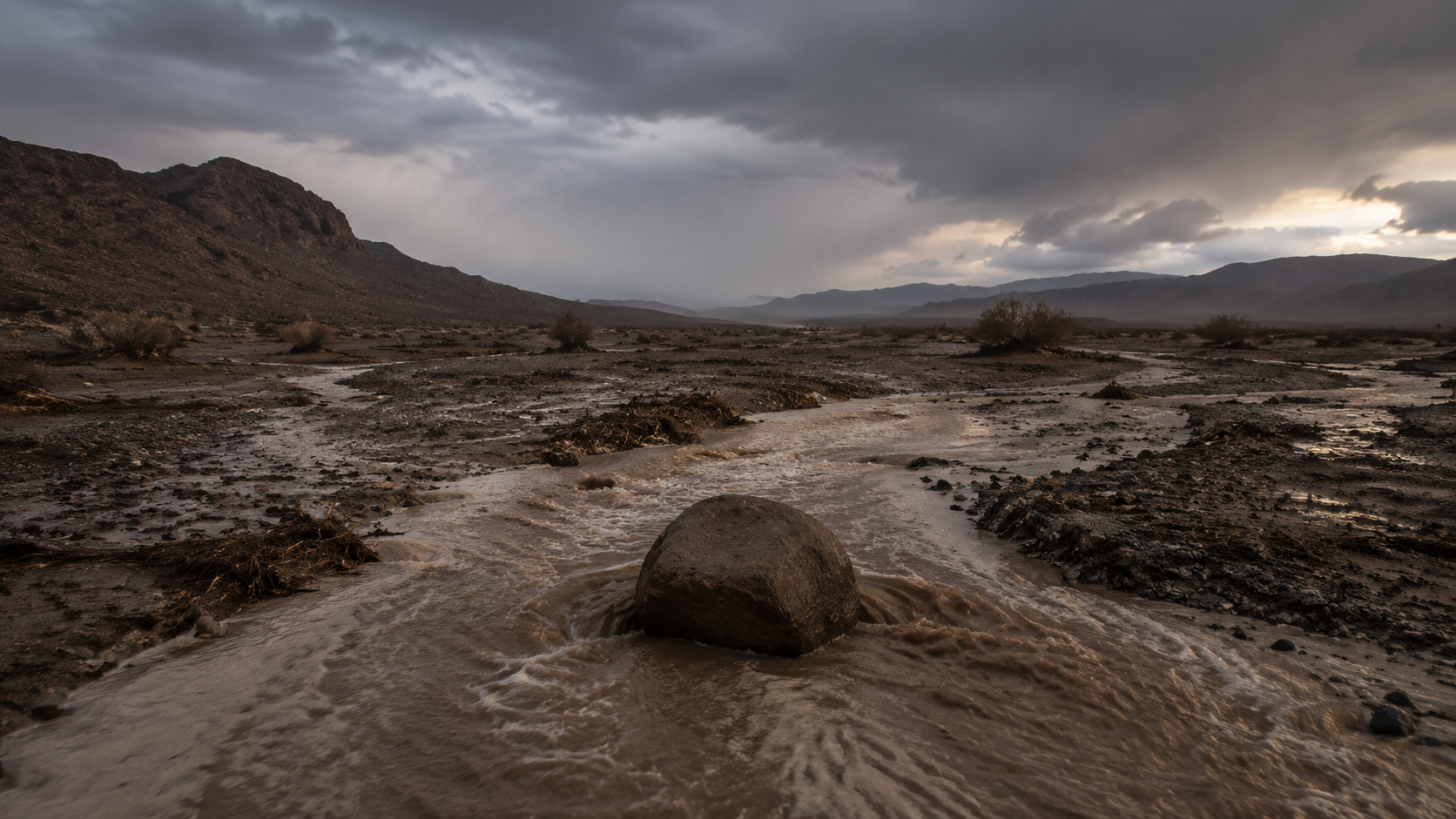 مجرى سيل بين الصخور تحت سماء مثقلة بالغيوم